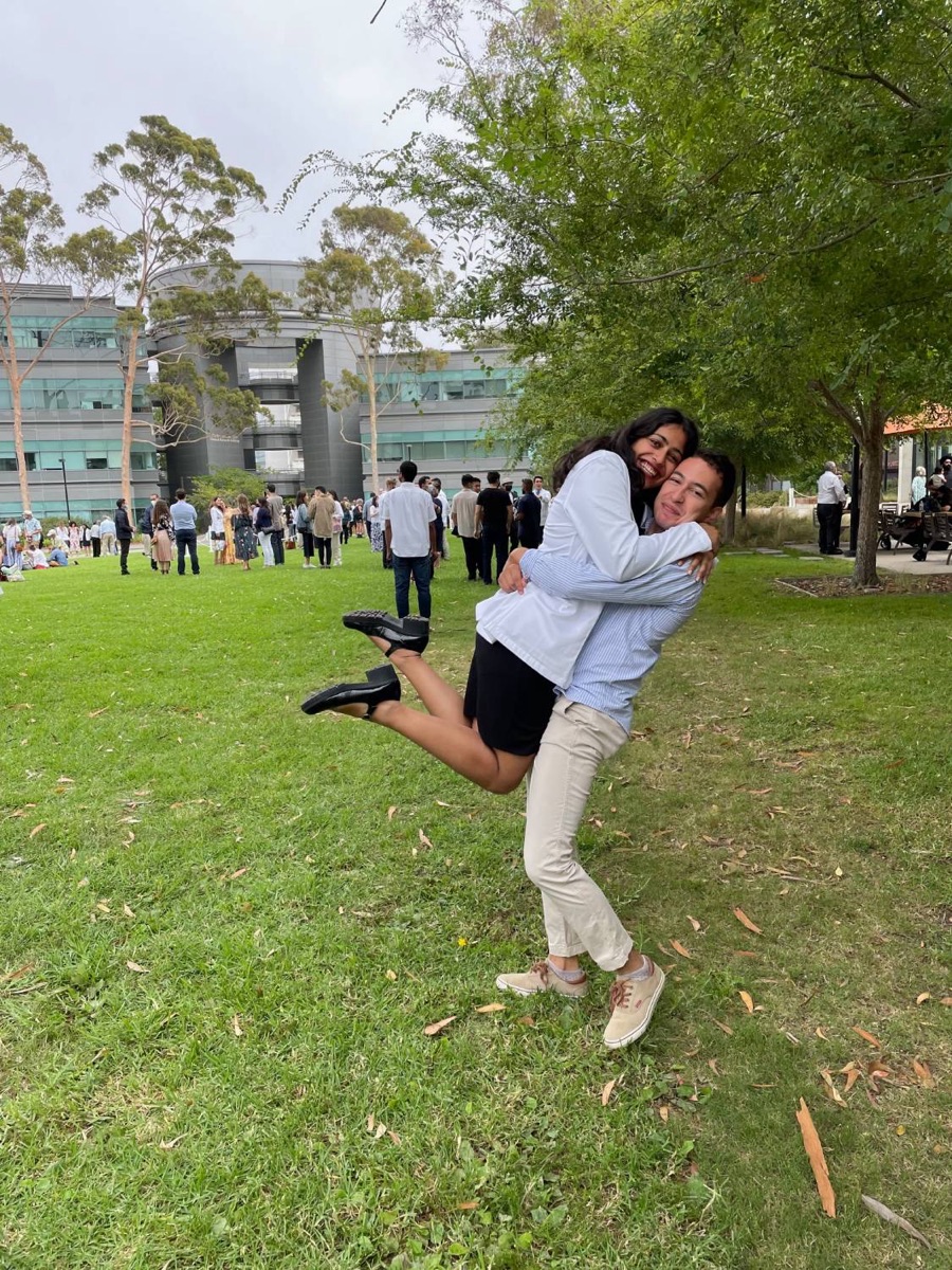 Tanya jumping into Marcos's arms on a lawn