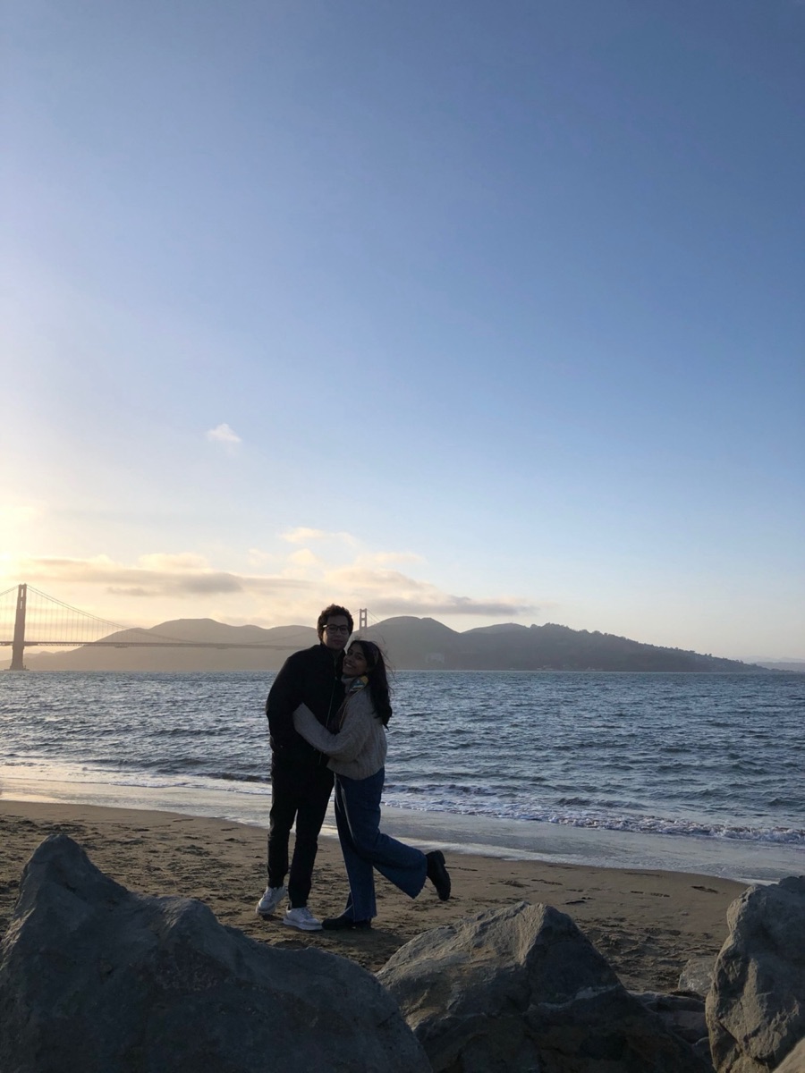 Marcos and Tanya hugging on the beach at sunset